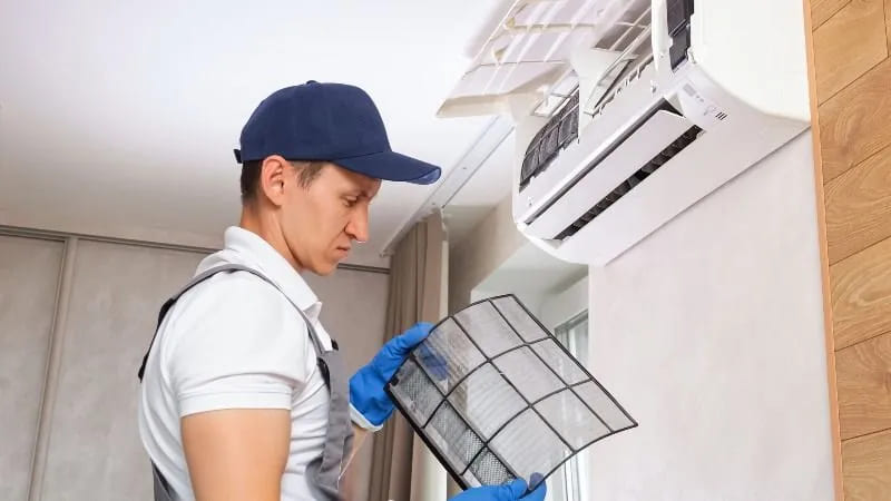 repairman detects dust on air conditioner filter