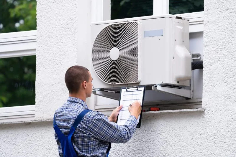 technician examing outdoor ac unit