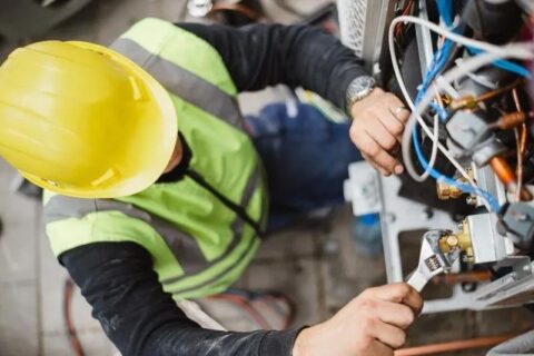 repair worker fixing outdoor ac unit