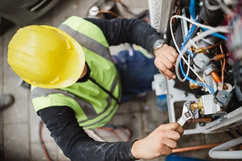 repair worker fixing outdoor ac unit