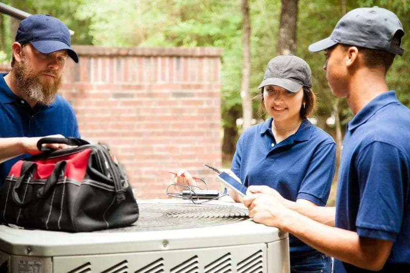 technicians examining ac unit