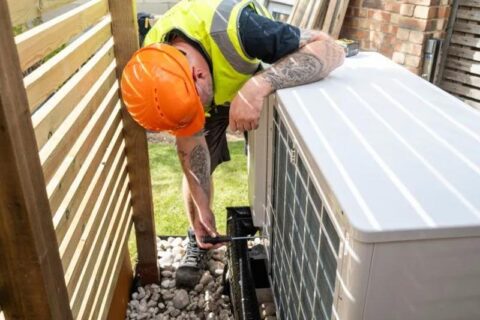 repair worker fixing outdoor ac unit