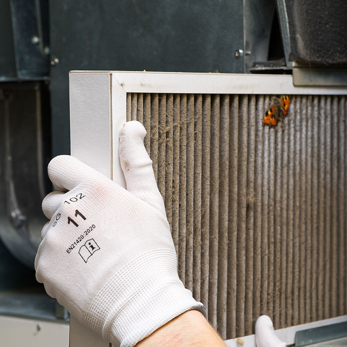 man looking at dirty air filter