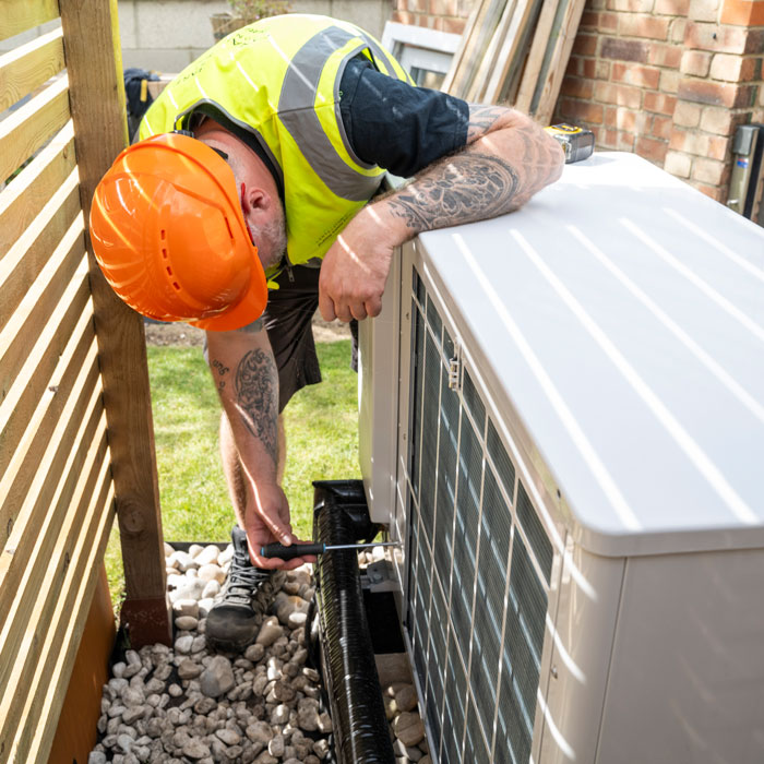 man working on home heat pump