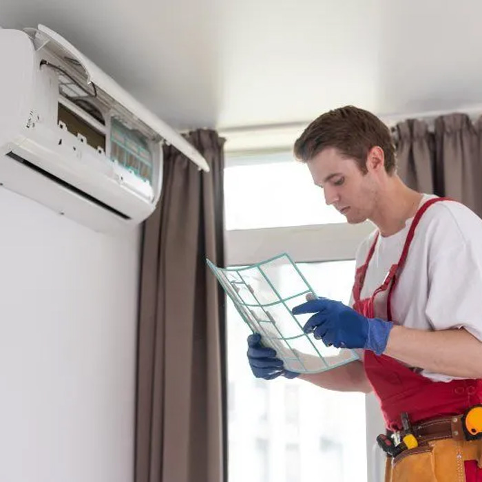 man inspecting ductless mini split