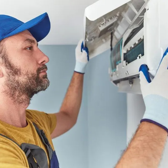 man inspecting ductless mini split