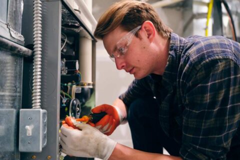 Furnace Technician Repairing Common Furnace Parts by Best Value A/C & Heating LLC