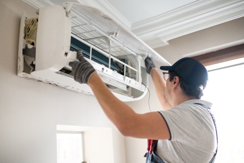 Technician servicing a wall-mounted air conditioner in Florida