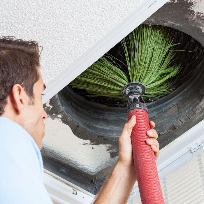 "Tech cleaning air ducts with a brush for air duct services in Volusia and Flagler Counties, FL. "