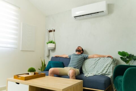 Man relaxing indoors with air conditioning and humidity control in Volusia and Flagler Counties