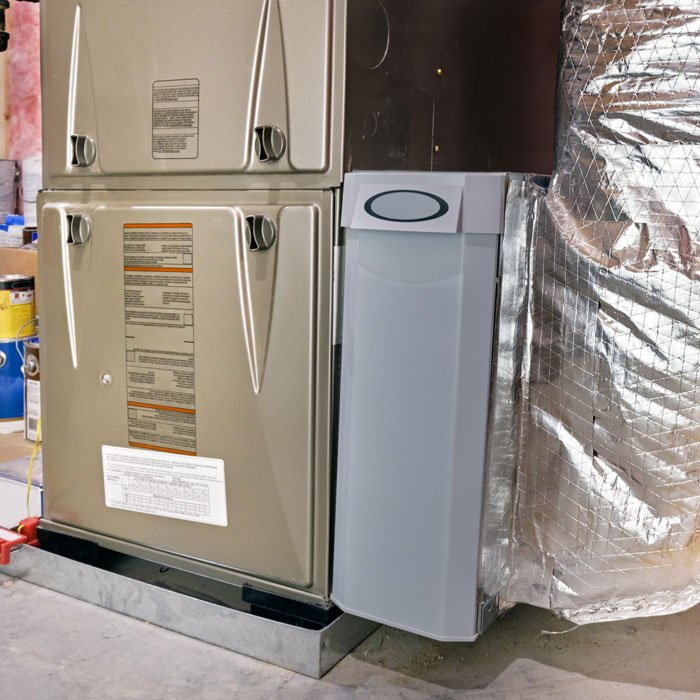 "Furnace installation with a technician setting up a UV air purifier in Volusia and Flagler Counties, FL. "