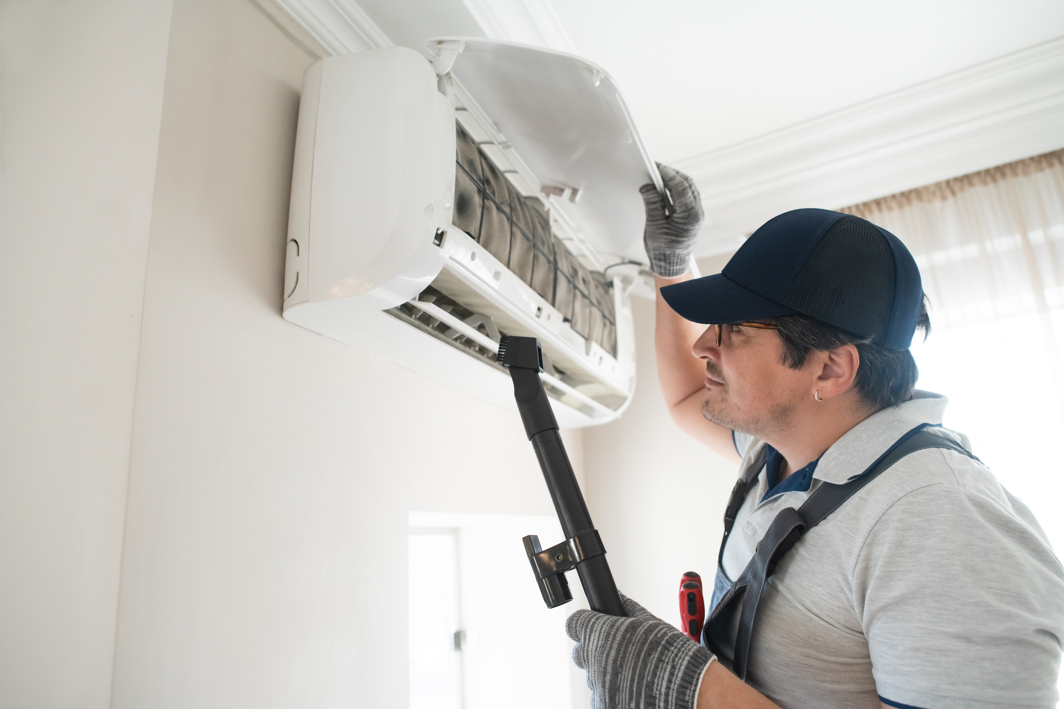 HVAC technician cleans dusty AC for cooling issues in Volusia and Flagler Counties