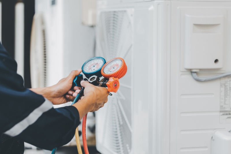 HVAC tech performing a 25-point HVAC inspection on an outdoor AC unit in Volusia & Flagler Counties