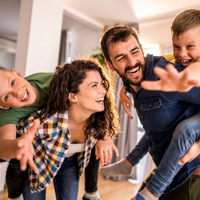 "Happy family indoors enjoying comfort, shows HVAC services in Volusia and Flagler Counties, FL. "