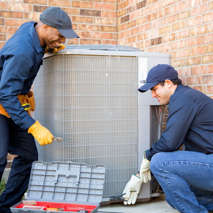 Techs installing an outdoor AC unit for A/C installation services in Volusia and Flagler Counties, FL.