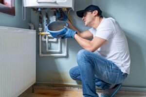 A technician repairs a water heater in a residential setting in Volusia and Flagler Counties, FL.