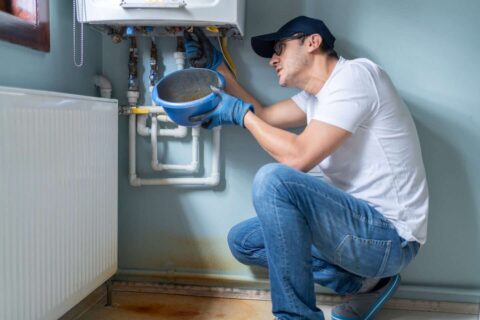 A technician repairs a water heater in a residential setting in Volusia and Flagler Counties, FL.